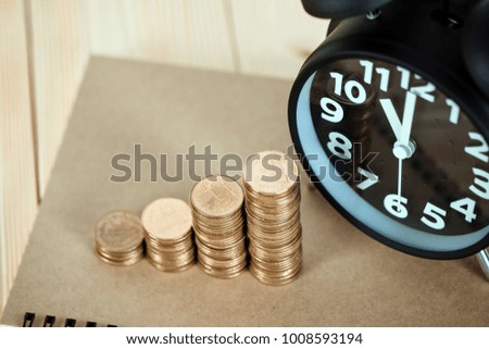 Steps of coins stack with vintage alarm clock and pen, notebook paper on wooden working table with copy space for text, financial and business planning concept idea. vintage tone.