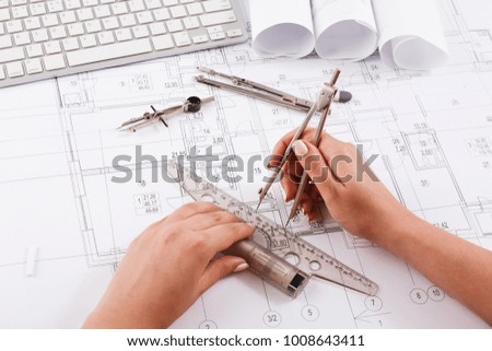 Architect drawing architectural project. Unrecognizable designer hands working with building blueprint, copy space