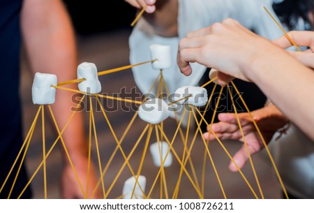Team building activities, use marshmallow and wood for house design. Personal development for business. Royalty-Free Stock Photo #1008726211