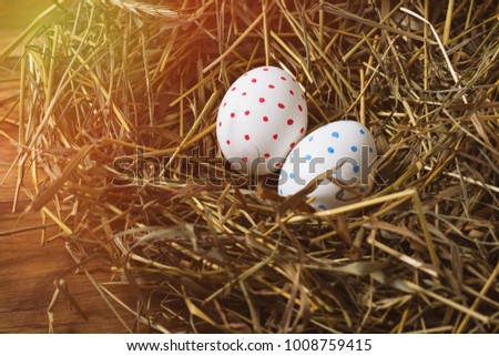 Easter Eggs in a Nest of straw on a wooden table. The concept of Easter.