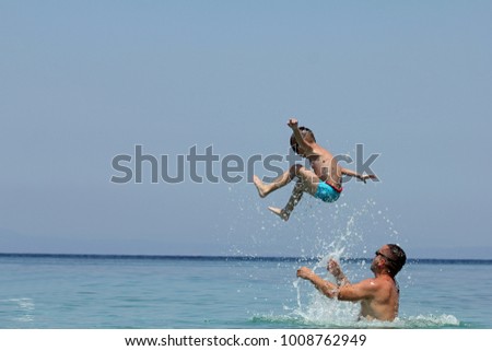 Father and son play in water