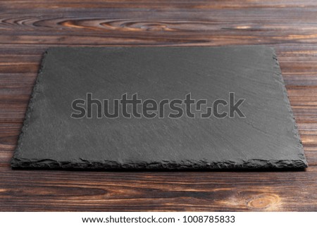 black slate stone on wooden background. copy space.