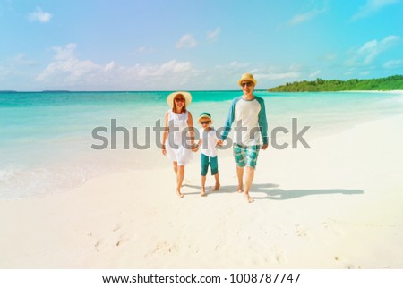 happy family with kid walking on beach