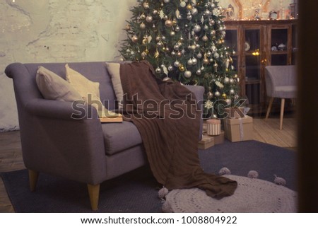 Stylish Christmas interior decorated in gray colors. Comfort home. Beautiful Christmas interior decoration for family celebration. grey brown tone. sofa, blanket, canteen
