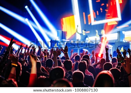 nightclub dj rave party with crowd of people hands up Royalty-Free Stock Photo #1008807130