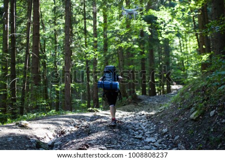 Hiking boy in forest following by drone