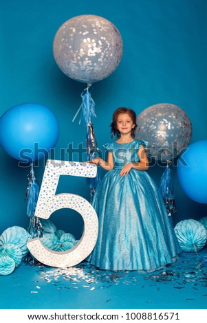 girl in the blue dress in the Studio with the balloon and with the number five
