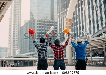 Team engineering happy smile , foreman look at complete site project plan lift hands to celebrate after construction project success.  Teamwork concept. Royalty-Free Stock Photo #1008829675