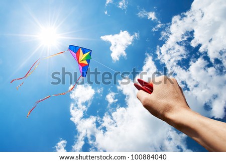kite flying in a beautiful sky with sun and clouds Royalty-Free Stock Photo #100884040