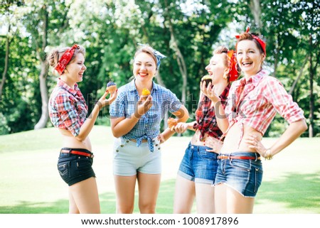 Group of friends at park having fun party. Cheerful girls with a cakes in hands