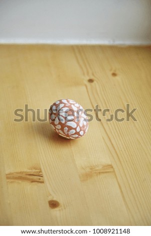 Egg painted with white floral pattern for Easter holiday. Natural concept, text space, wooden background.