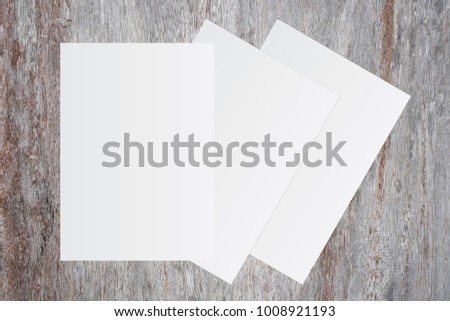 Blank white paper on brown wooden background for text input.