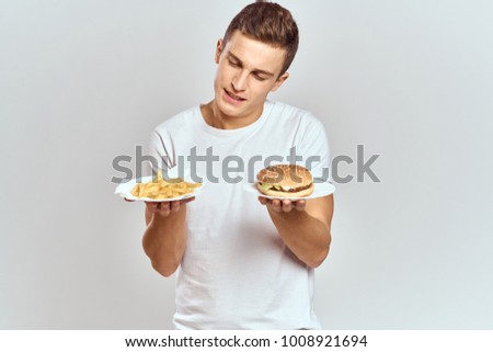 man with fast food on a light background                               