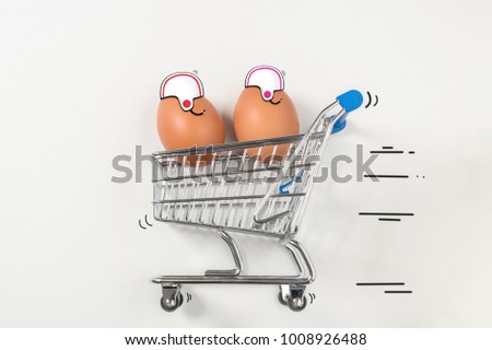 Two Easter egg is riding in the shopping trolley and acting like a racers.