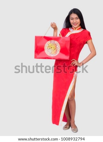 Beautiful Woman in Chinese traditional dress holding Carrying a shopping bag and smiling, isolated on white background, Chinese New Year concept.