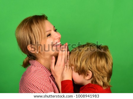 Woman and little boy with smiling faces on green background. Mother and son playing games. Parenthood and happy moments concept.