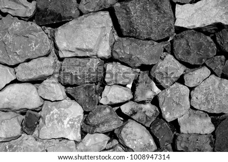black and white picture of a wall made of stones.