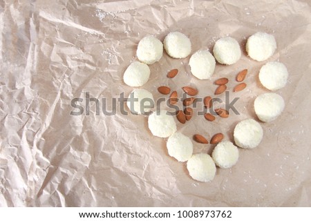 Delicious candies with coconut and almonds in the form of a serdcaon background of old paper. Greeting card for's Day, 8 March, Birthday, Valentines Day with place for text