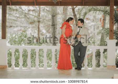 photo shoot of groom and bride with flowers and saxophone