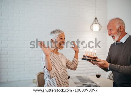 Mature couple holding a birthday cake
