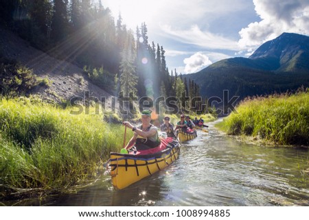 Group paddling down the whitewater of the Nahanni River in the Northwest Territories.