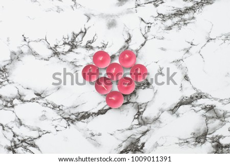 Little pink scented candles in heart shape on white marble background. Flat lay, top view. Romantic Valentine's concept.