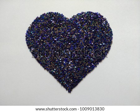 blue glass beads on heart shaped Royalty-Free Stock Photo #1009013830
