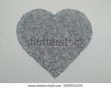 silver glass beads on heart shaped Royalty-Free Stock Photo #1009016245