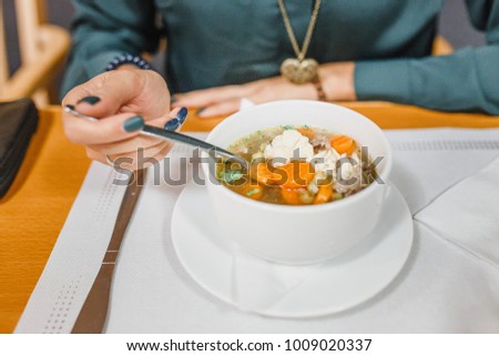 Women eating chicken soup close up