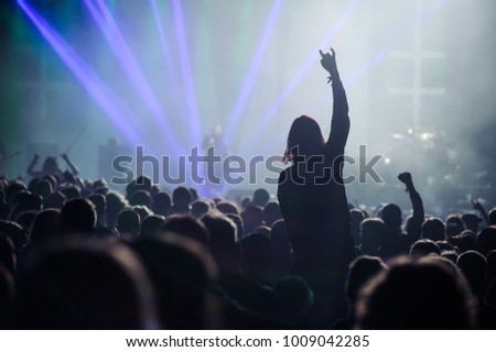 Music fans enjoying rock concert with hand in the air
