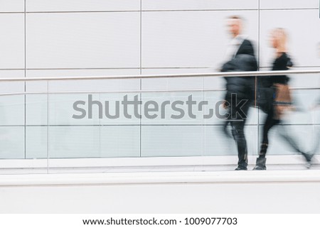 blurred business people walking in a futuristic corridor, including Copy space