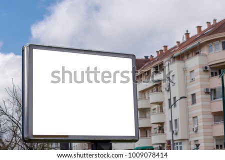 Blank billboard with apartment building in the background, housing concept