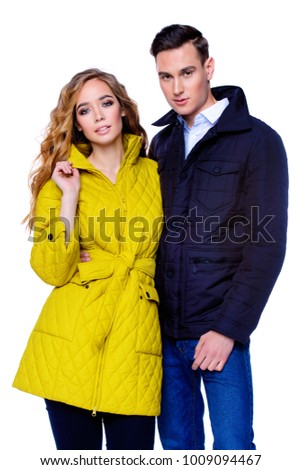 Fashion shot. Couple of young people in winter clothes posing at studio. Autumn and winter clothes.