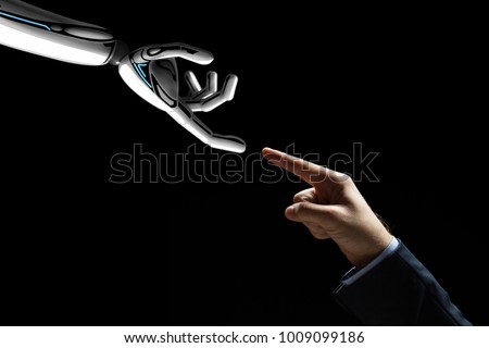 artificial intelligence, future technology and communication concept - robot and human hand connecting fingers on black background