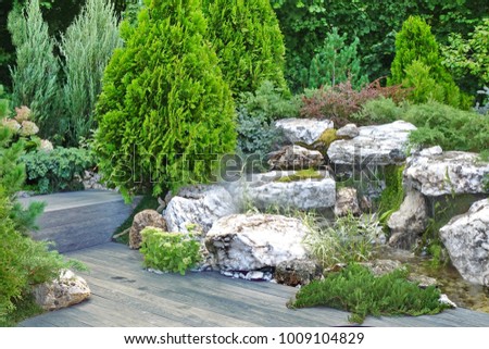 Artificial Tropical Pond, Brook And Waterfall In Decorative Backyard Garden With Weatherproof Patio Floor