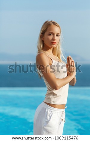 Young woman doing yoga outdoor, sea view