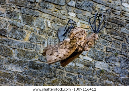 Wooden cupid on stone wall