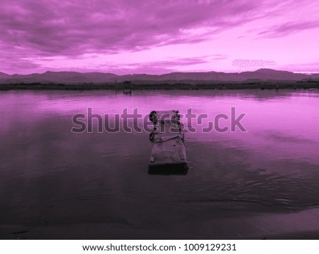 Purple sunset and old fishing wooden pier and river on a background of mountains. Meditative relaxing natural landscape
