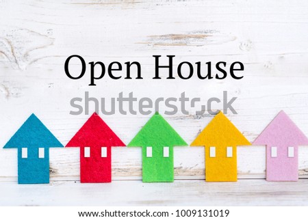 Open House Concept with Small Colorful Houses in a Row on a Wooden Background