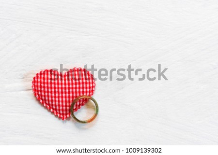 Valentine, love and wedding background concept. Marble ring with red heart on white wood table background. Picture for add text message. Backdrop for design art work.