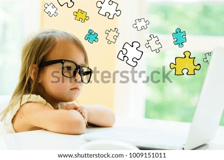 Puzzle Pieces with little girl using her laptop