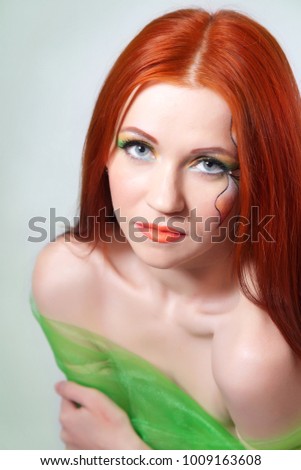 Portrait of beautiful red-haired girl with a flower painted on his face
