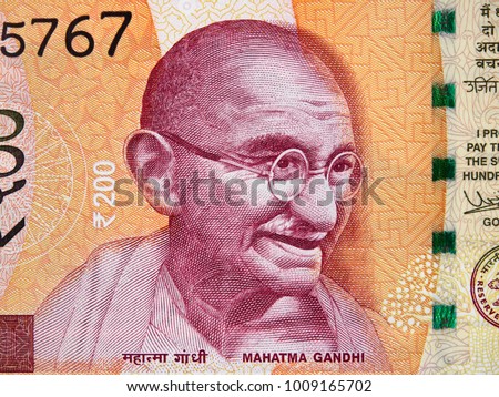 Mahatma Gandhi face portrait on India 200 rupee (2017) banknote close up macro, leader of the Indian independence movement, father of nation Royalty-Free Stock Photo #1009165702