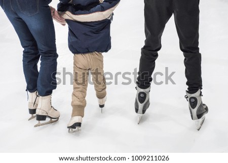Happy family ice skating at rink. Winter activities