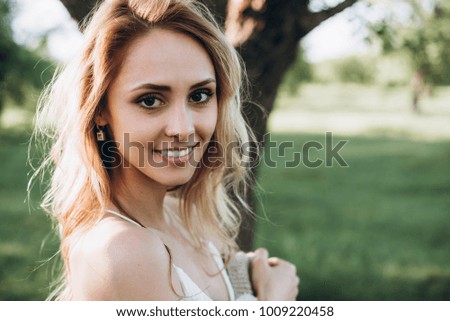 Portrait of a charming smiling girl which spends time in the park