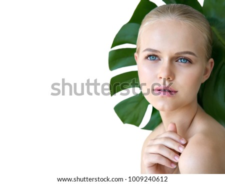 Young  beautiful blonde model with green leaf isolated on white. Beauty natural make up. Spa and wellness and skin care concept.  Close up, selective focus, copy space.