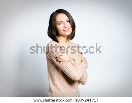 Portrait of an attractive young girl freezing. All on gray background.