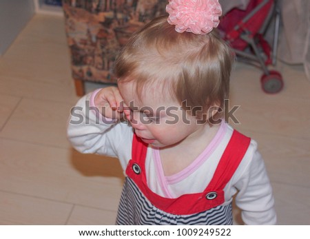 the child cries and wipes away tears. Little girl is crying, bored. The girl was upset. Royalty-Free Stock Photo #1009249522