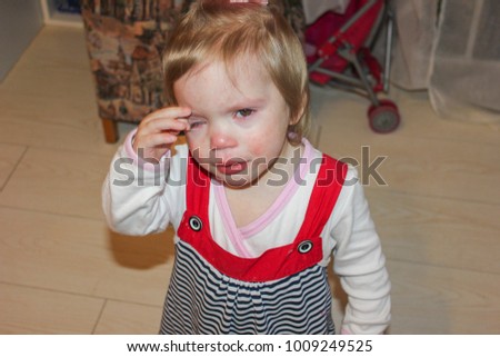 the child cries and wipes away tears. Little girl is crying, bored. The girl was upset. Royalty-Free Stock Photo #1009249525