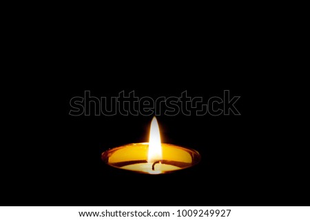 Mourning Condolence Memorial funeral cremation ceremony concept. Single burning isolated candle light on  black background. Dark. Peace. Royalty-Free Stock Photo #1009249927